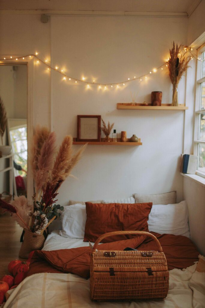 Tiny bedroom decorated with warm autumn colors, cozy lighting and soft seasonal accessories